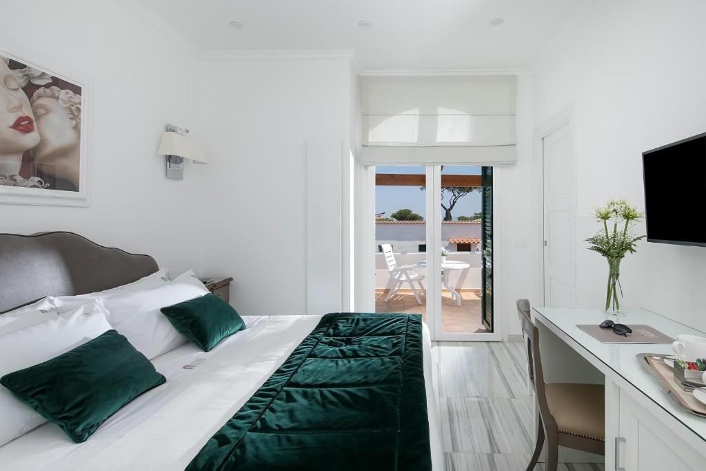 um quarto com uma cama, uma secretária e uma televisão em Vittoria Colonna Luxury B&B em Ischia