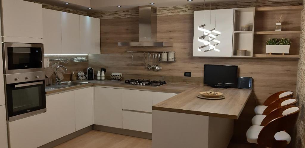 a kitchen with white cabinets and a wooden counter top at Casarelax in Abano Terme