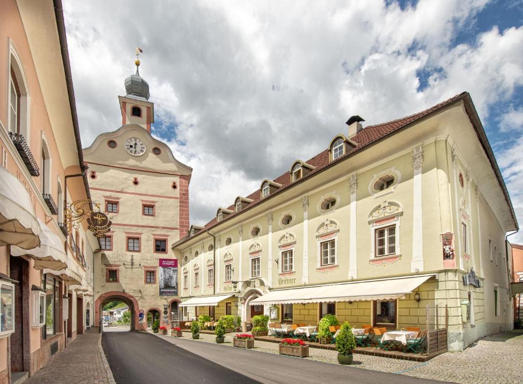 a building with a clock tower next to a street at Hotel Gasthof Prunner in Gmünd in Kärnten