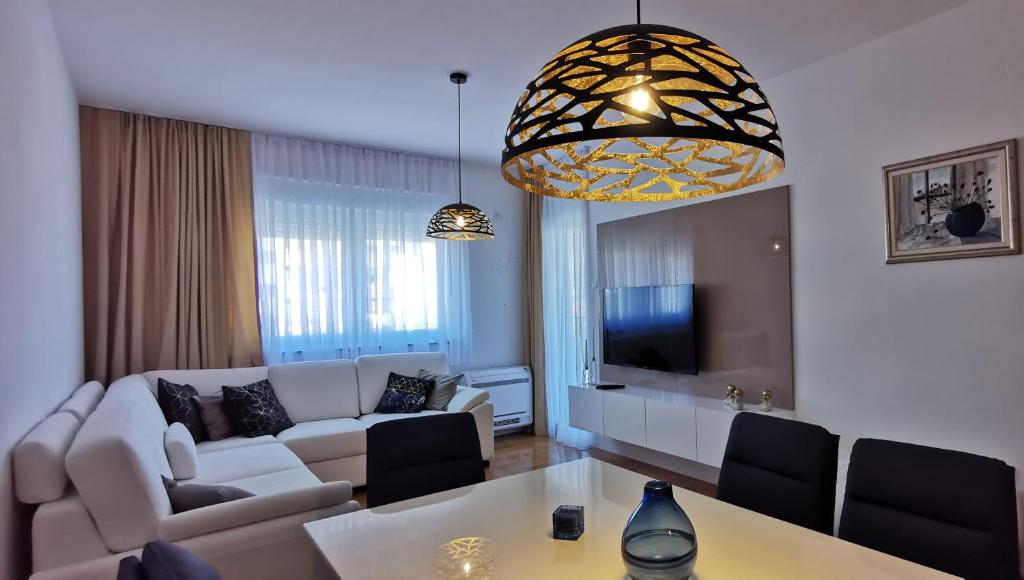 a living room with a white couch and a table at Apartman Sunlight in Trebinje