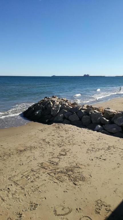 a beach with a pile of rocks and the ocean at PISO EN MALVARROSA in Valencia