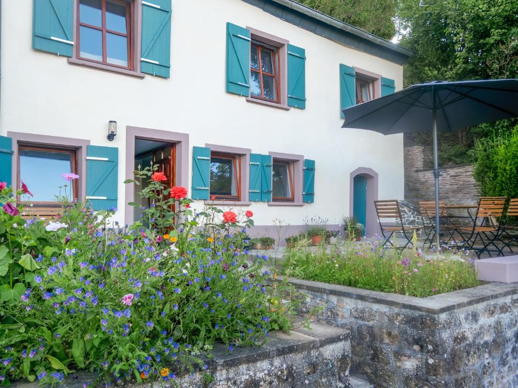ein Haus mit bunten Blumen und einem Sonnenschirm in der Unterkunft Das Kartenhaus in Saarburg