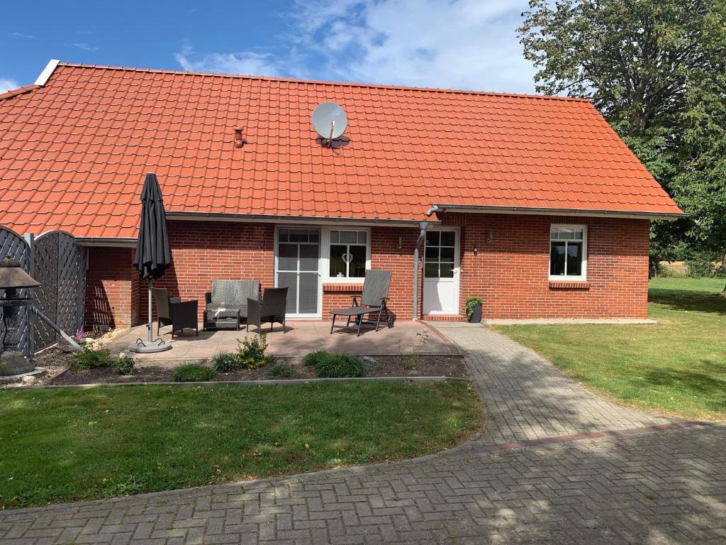een rood bakstenen huis met een oranje dak bij Weideblick in Upgant-Schott