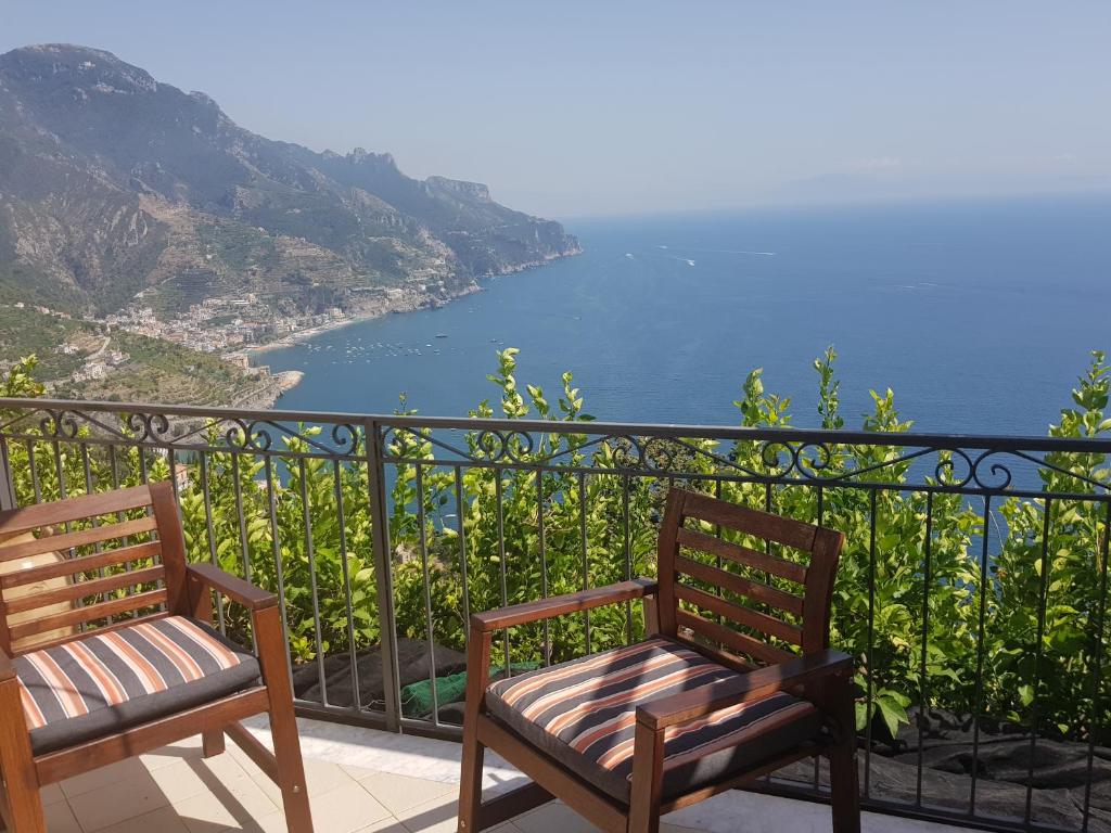 two chairs sitting on a balcony looking at the ocean at Le Esperidi House in Ravello