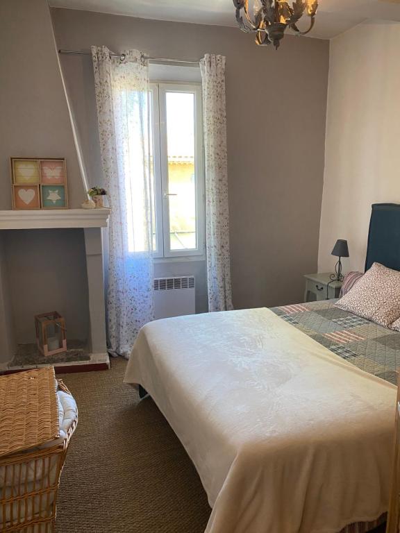 um quarto com uma cama grande e uma janela em Maison Ventoux 1 Luxe Calme Central Linge fourni em Malaucène