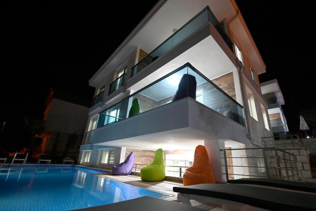 une maison avec des chaises colorées à côté d'une piscine dans l'établissement Villa Noble, à Demre