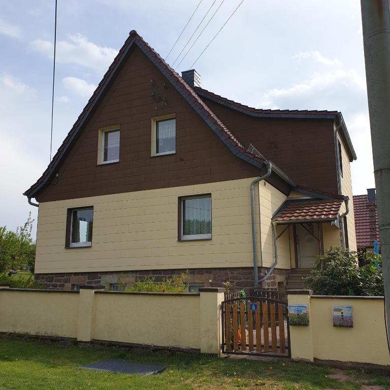 dom z brązowym dachem i płotem w obiekcie FeWo Zimmermann w mieście Etterwinden
