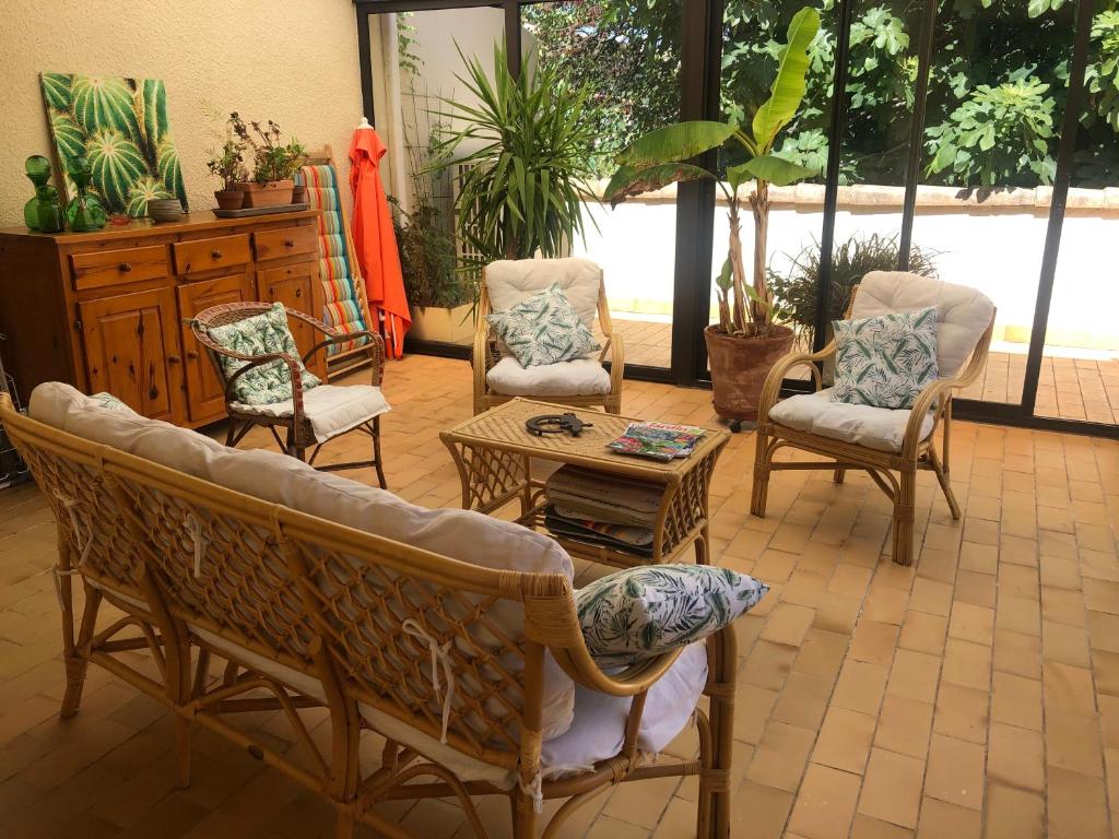 ein Wohnzimmer mit Stühlen und einem Tisch in der Unterkunft Maison Vigneronne in Loupian