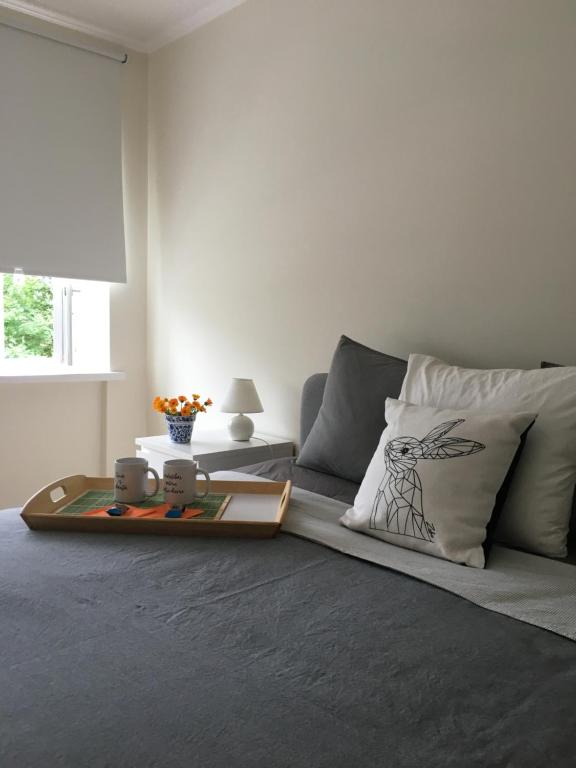 a bedroom with a bed with a table and pillows at Fox Apartments - Pie Lapsas in Priekuļi