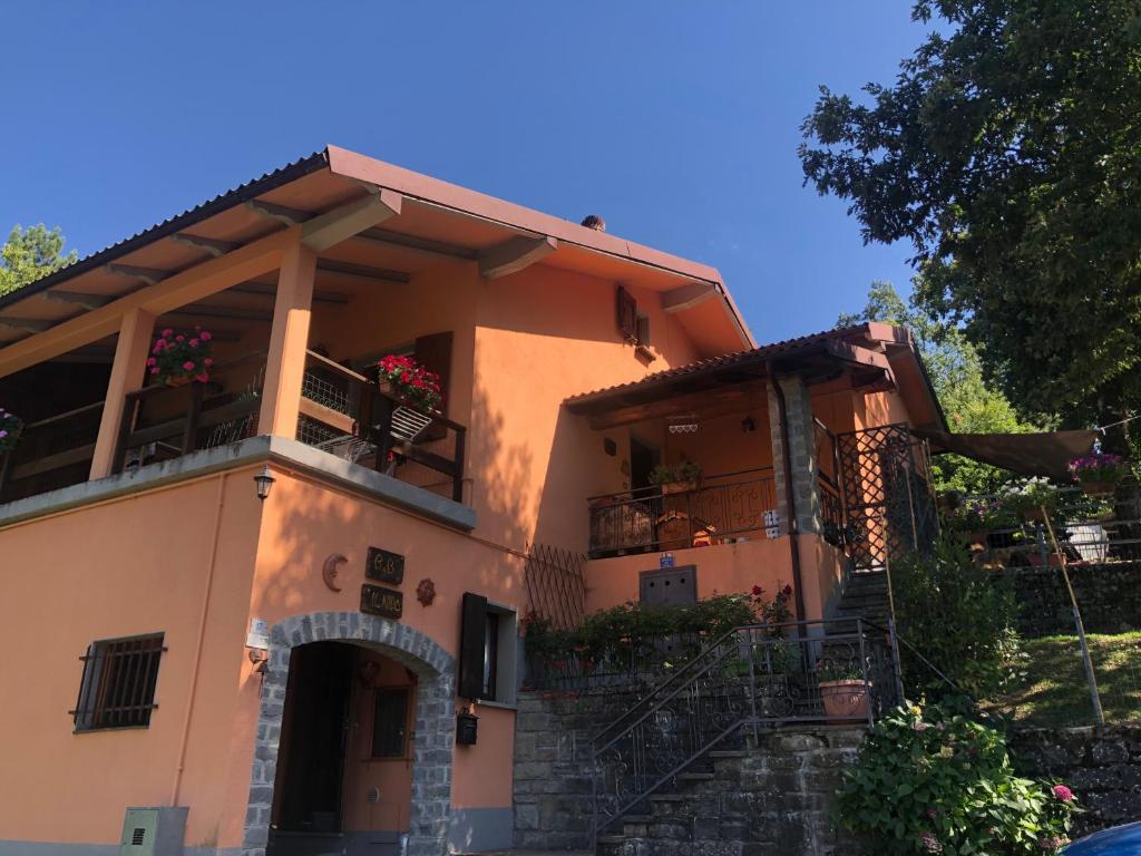 une grande maison avec un balcon et des fleurs. dans l'établissement B&B Il Nido, à Riolunato