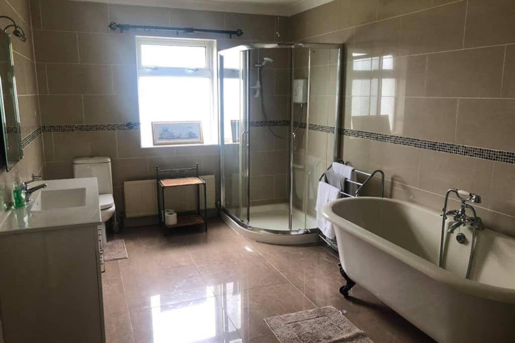 a bathroom with a tub and a shower and a sink at Luí na Gréine in Gweedore