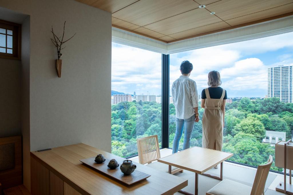 札幌市にあるONSEN RYOKAN 由縁 札幌の大窓を見下ろす男女