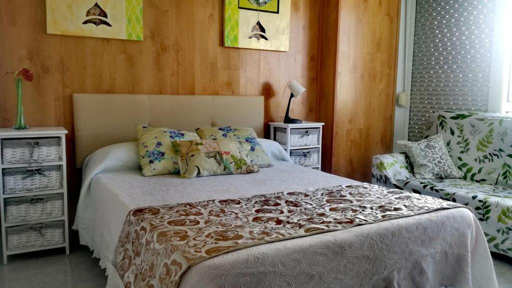 1 dormitorio con 1 cama y 1 silla en Pensión Residencia Miñones, en Bayo Grande