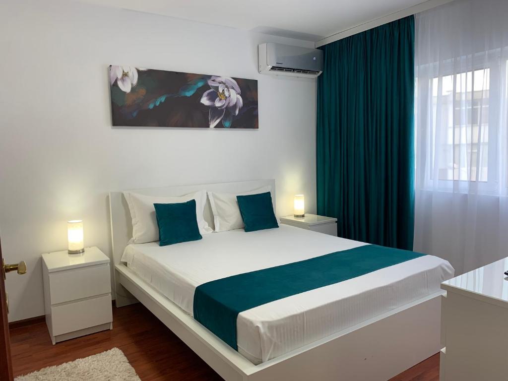 ガラツィにあるAna Center Apartmentの白いベッドルーム(青色をアクセントにした大型ベッド1台付)