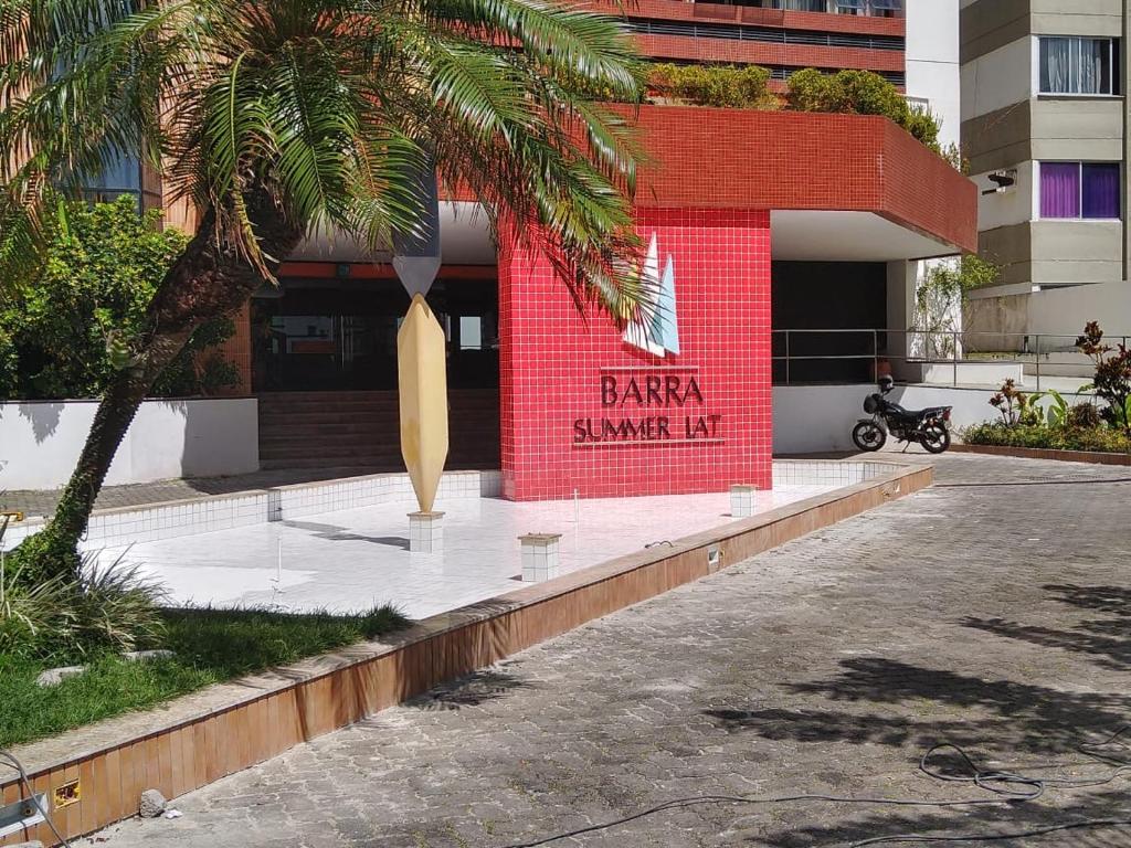 une planche de surf devant un bâtiment dans l'établissement Barra Summer flat, à Salvador
