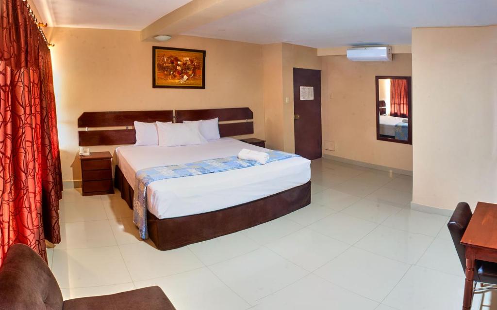 um quarto com uma cama grande num quarto em Hotel America Pucallpa em Pucallpa