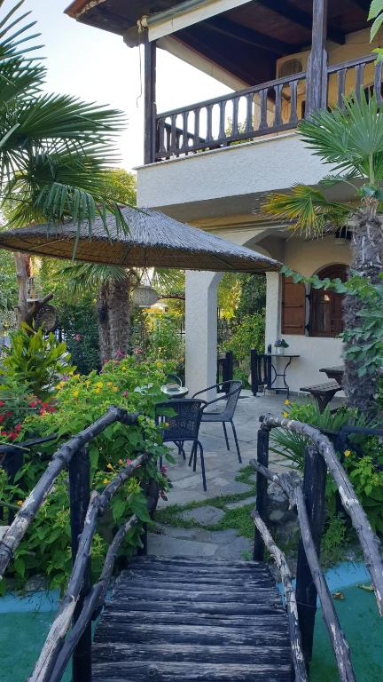 een houten pad dat leidt naar een huis met een patio bij Casa del mare ex Exohiki Katoikia in Paralia Katerinis