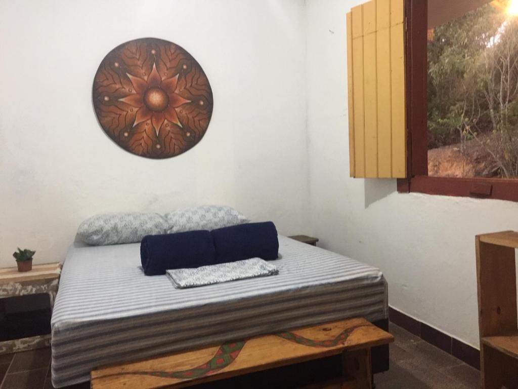 uma cama num quarto com um relógio na parede em Morada da Águia em Lavras Novas