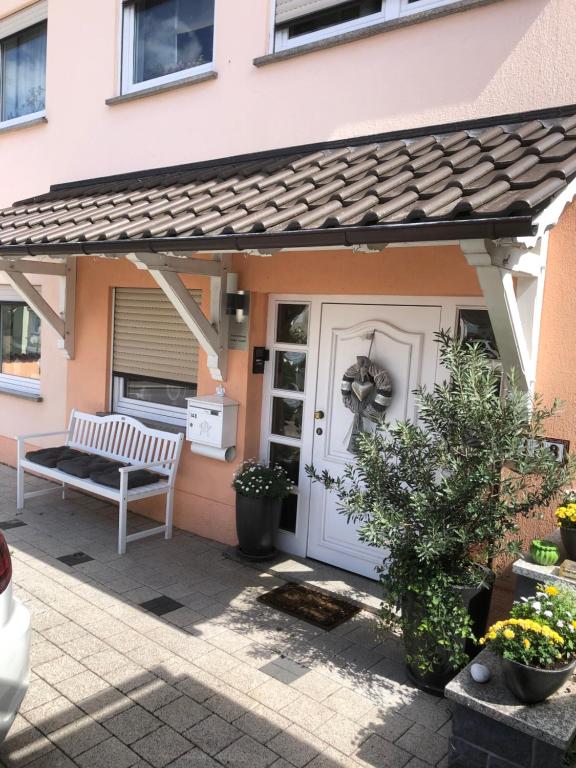 a patio with a white door and a bench at Kleine Auszeit in Neunkirchen