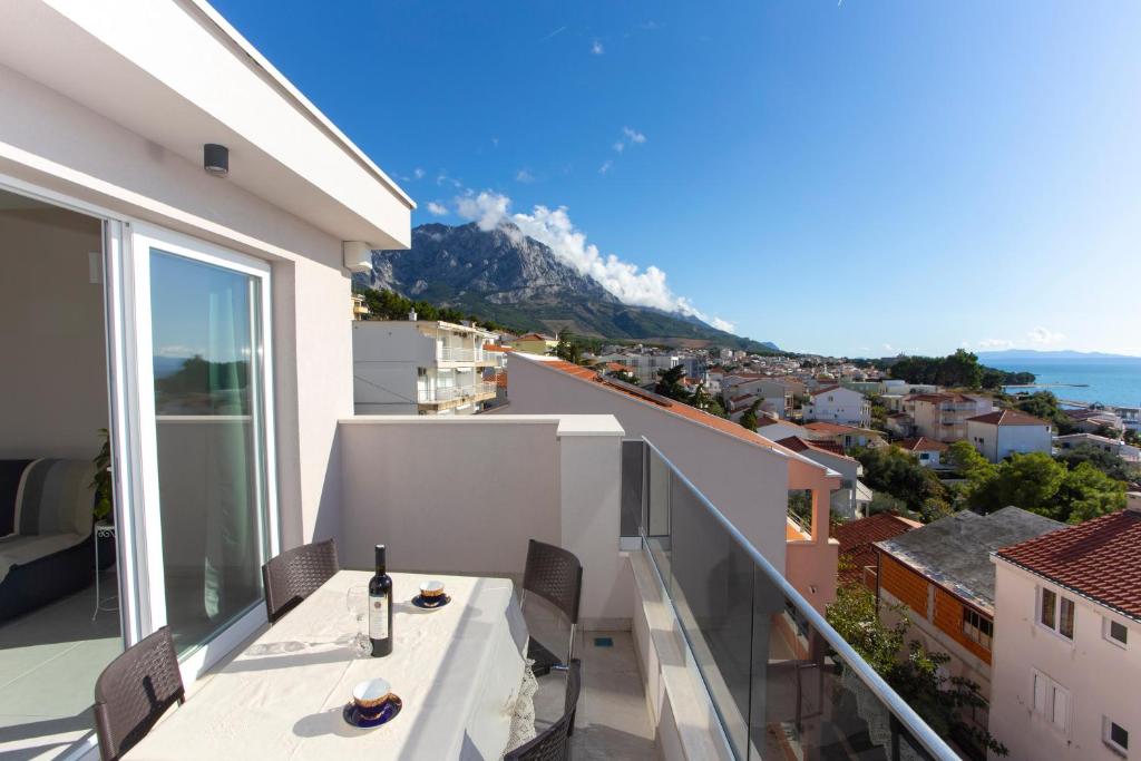 a balcony with a table and a view of a mountain at Apartments Medvidovic in Baška Voda