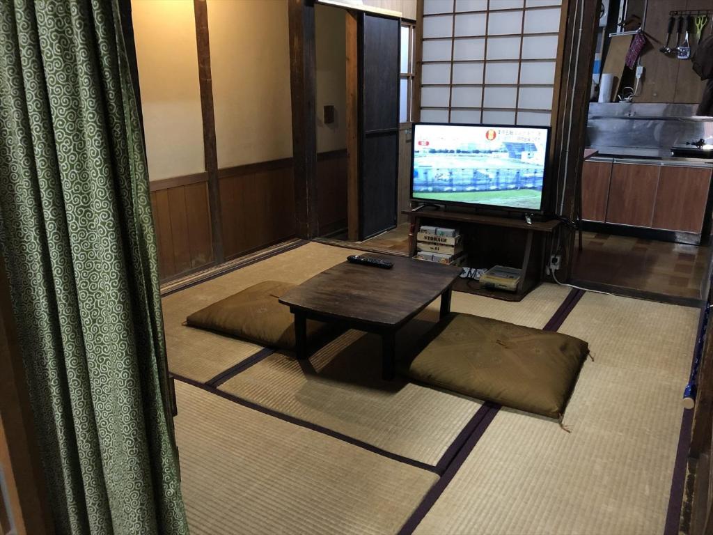 a living room with a table and a television at 437 Kinomotocho - Hotel / Vacation STAY 8616 in Kumano