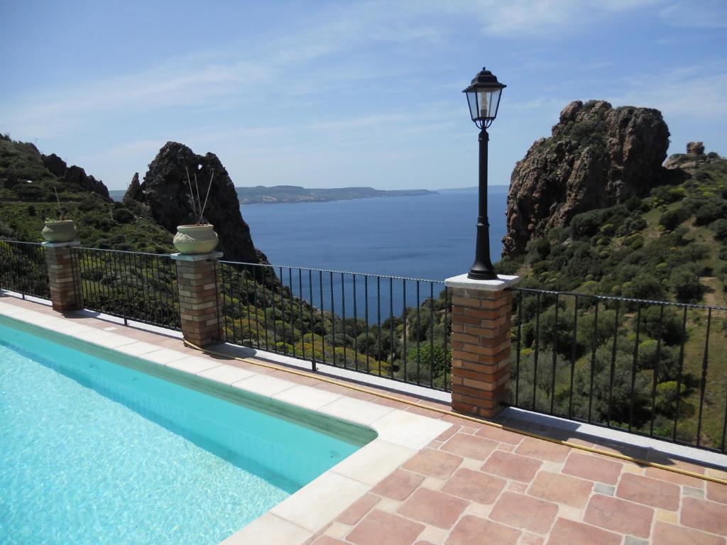 a pool with a street light and a view of the water at VILLA TRAMONTI SUL MARE in Nebida