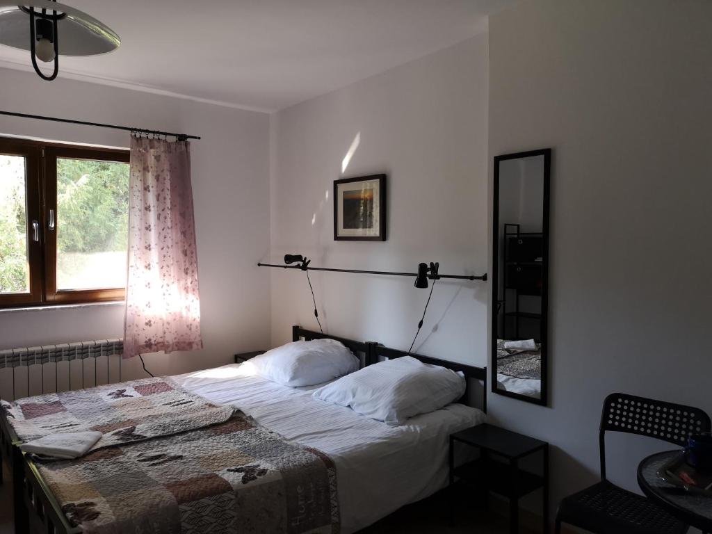 Schlafzimmer mit einem Bett, einem Spiegel und einem Fenster in der Unterkunft Dwerniczek 7 in Dwerniczek