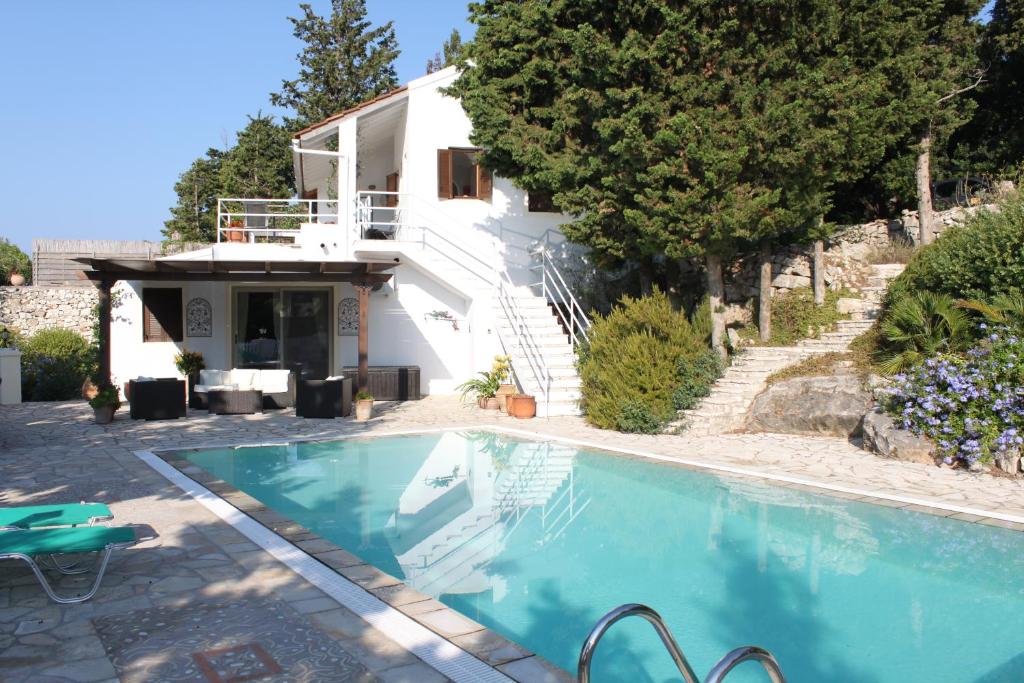 a villa with a swimming pool in front of a house at Villa Paparouna in Magaziá