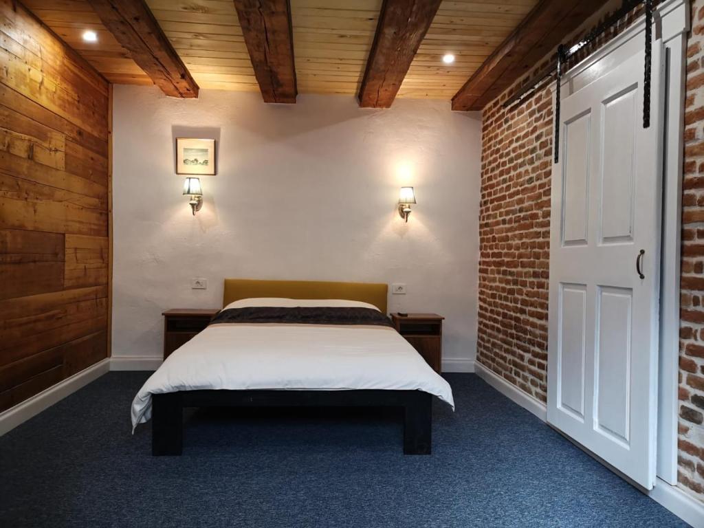 a bedroom with a bed and a brick wall at Guesthouse Postavarului in Braşov