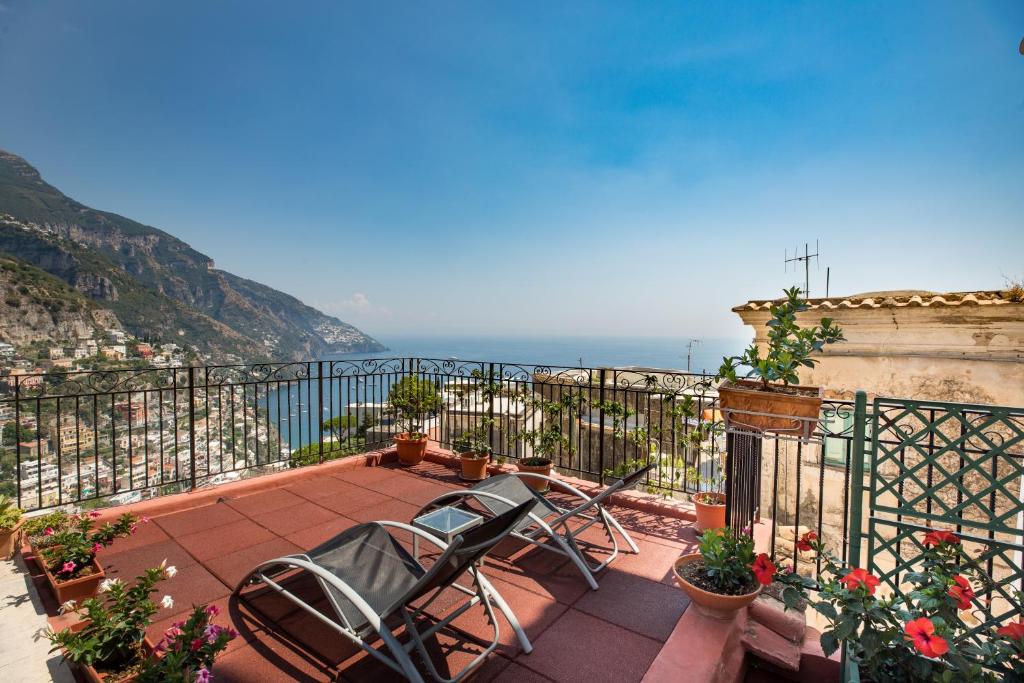Un balcón con dos sillas y vista al mar. en Casa Alessandra - De Vivo Realty Positano, en Positano