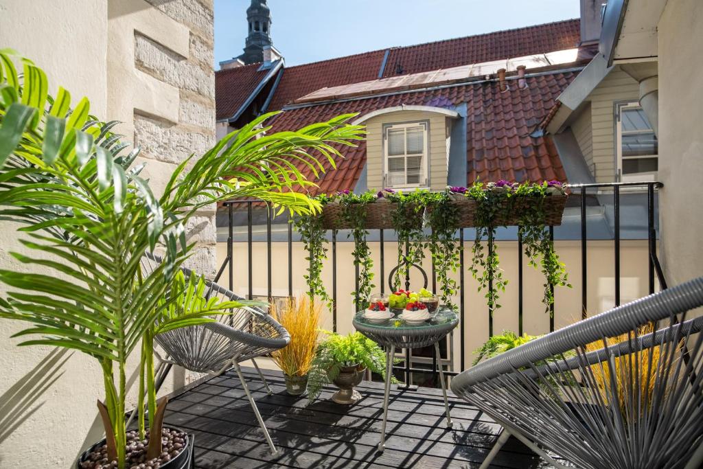 a balcony with chairs and plants on a fence at Rataskaevu Boutique - 7 Unique Apartments in Tallinn