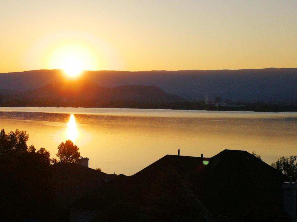 a sunset over a large body of water at Casa Grande Lakeview House in West Kelowna
