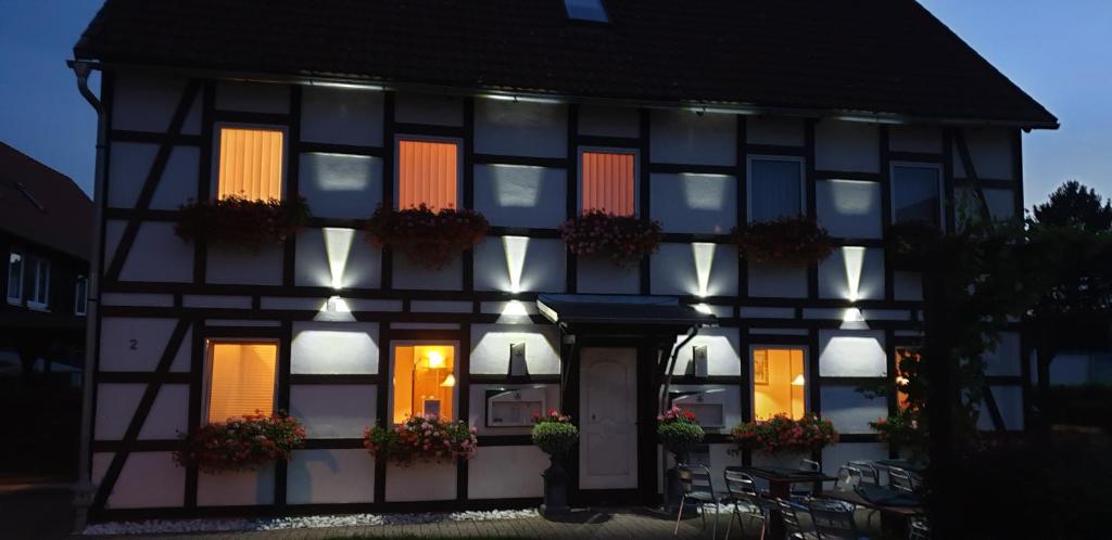 a black and white building with lit up windows at La Fontana in Langelsheim