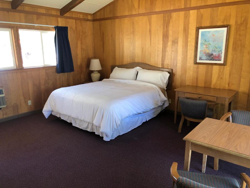 a bedroom with a bed and a desk and a table with chairs at Meadowcliff Lodge Coleville in Coleville