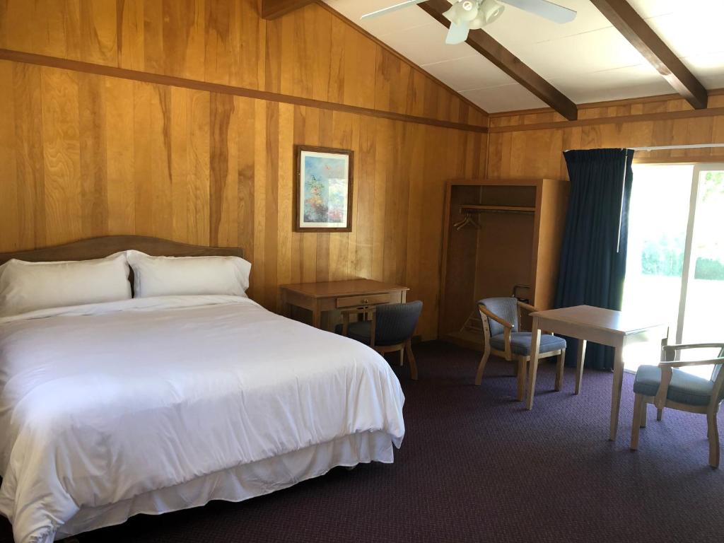 a bedroom with a bed and a table and a desk at Meadowcliff Lodge Coleville in Coleville