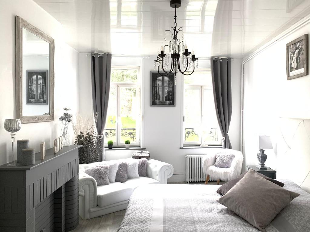 uma sala de estar branca com uma cama e um lustre em La Felicità classement ****vue Cathédrale! em Boulogne-sur-Mer