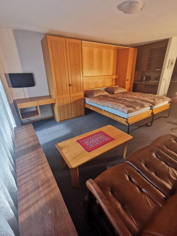 una habitación de hotel con dos camas y un sofá en Alpablüamli, en Pany