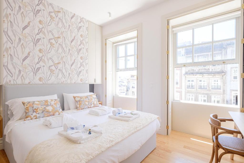 ein weißes Schlafzimmer mit einem Bett mit Handtüchern darauf in der Unterkunft BOUTIQUE Rentals- THE RIBEIRA***** Apt great views in Porto