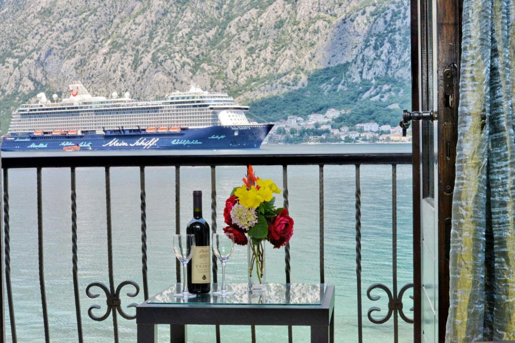 una mesa con una botella de vino y un crucero en Apartments Saxo, en Kotor