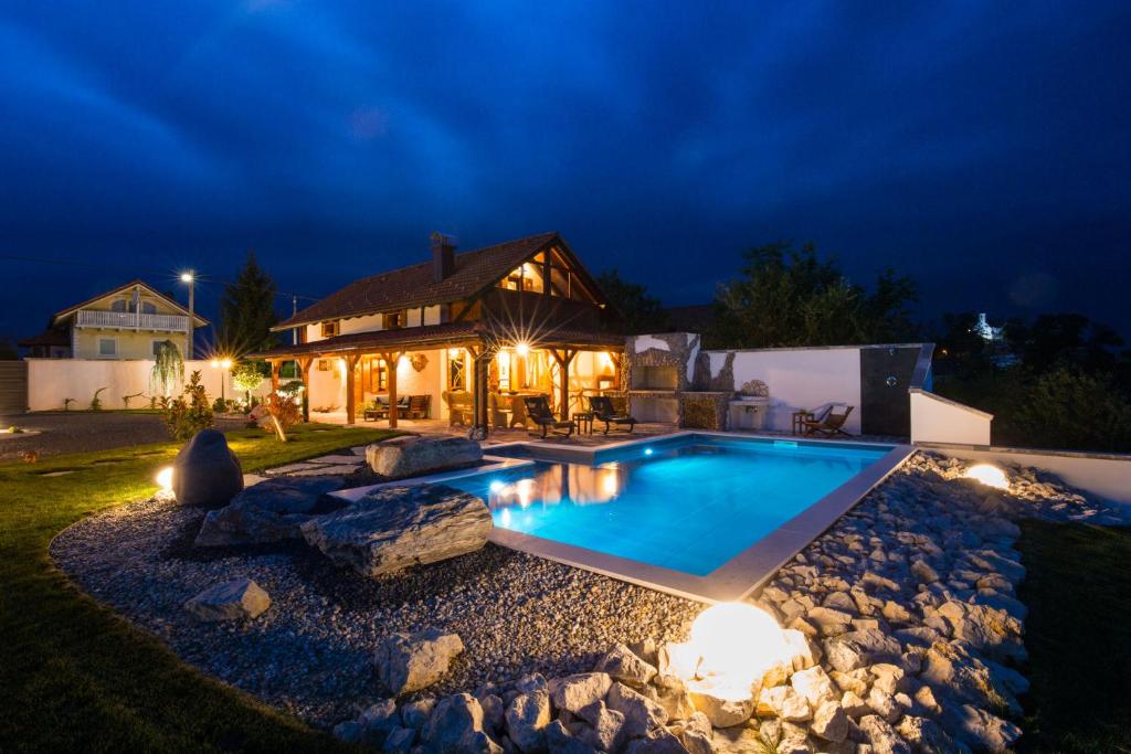 a swimming pool in the yard of a house at night at Villa Brallissima in Sveti Martin na Muri