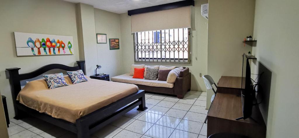 1 dormitorio con cama y sofá en Apartamento mediano ideal para parejas o ejecutivos, en Manta