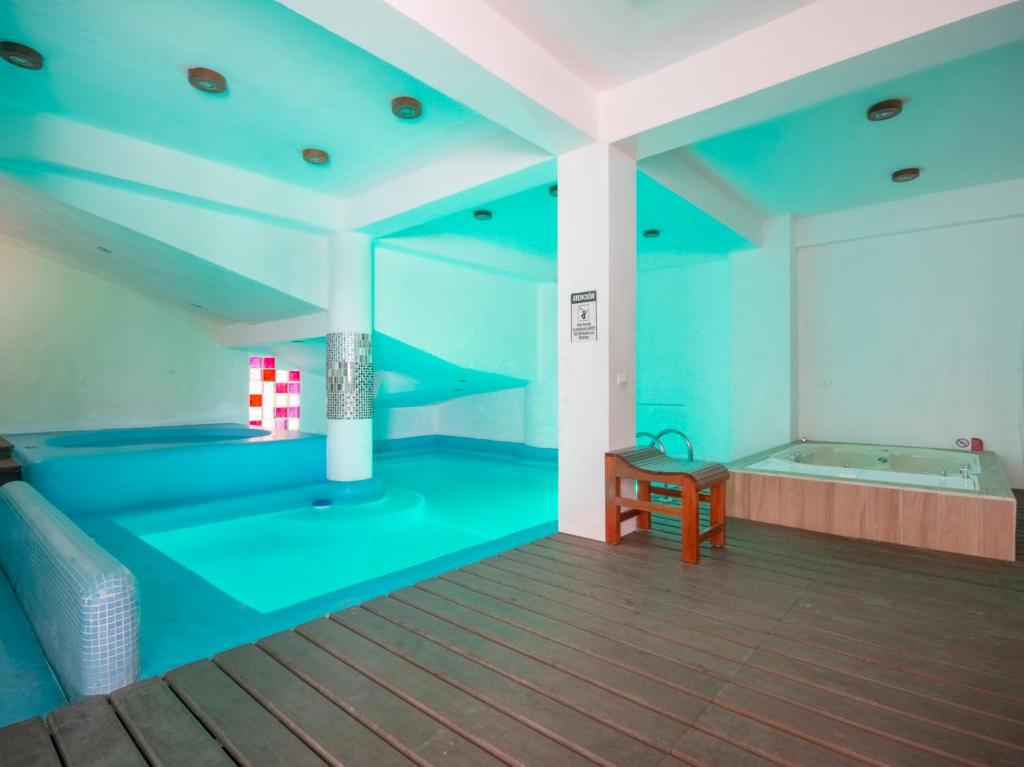 a blue room with a tub and a table at Hotel Spa Shalam in Coatepec