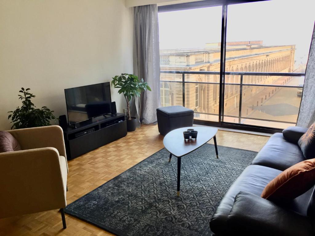 een woonkamer met een bank en een tafel bij Rustig appartement met zeezicht dicht bij het centrum in Oostende