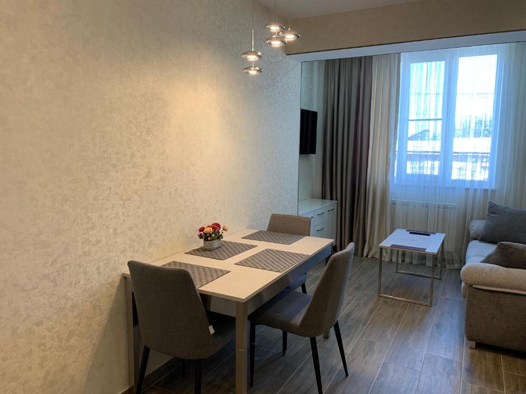 un soggiorno con tavolo, sedie e divano di Concept Apartments a Gyumri