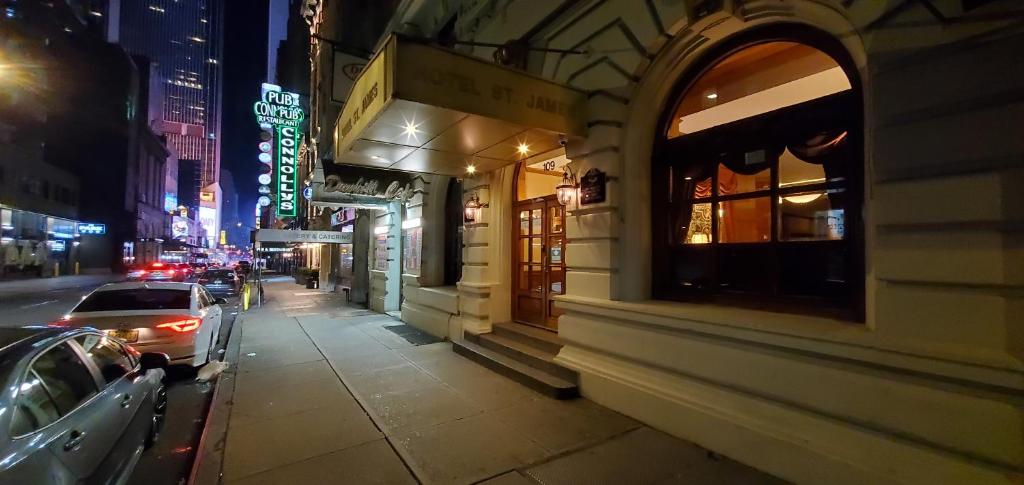 een stadsstraat 's nachts met auto's geparkeerd op de stoep bij Hotel St. James in New York