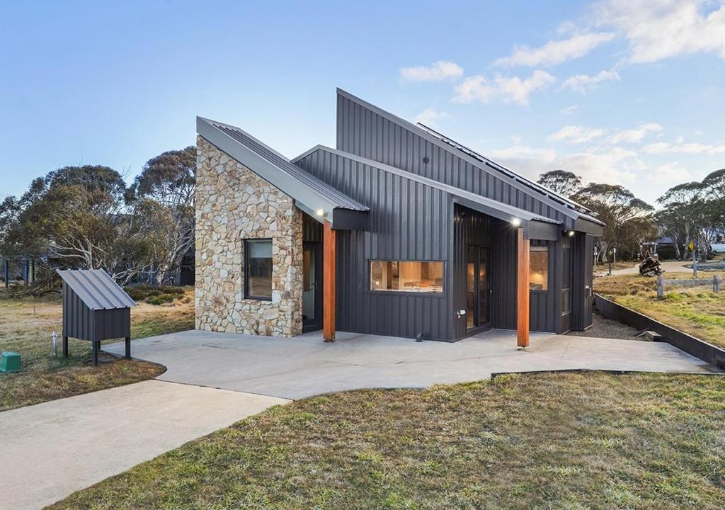 a black house with a stone facade at Blackout in Dinner Plain