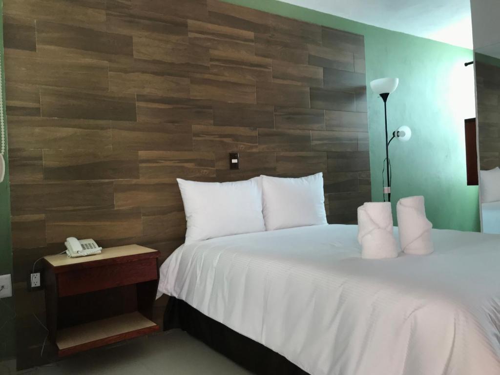 een slaapkamer met een bed en een houten muur bij Malinalli Express in Apizaco