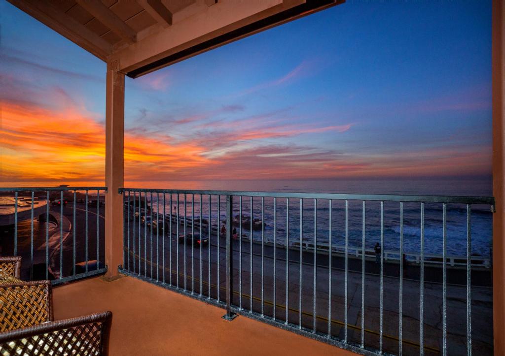 uma vista para o oceano a partir de uma varanda ao pôr-do-sol em Pantai Inn em San Diego