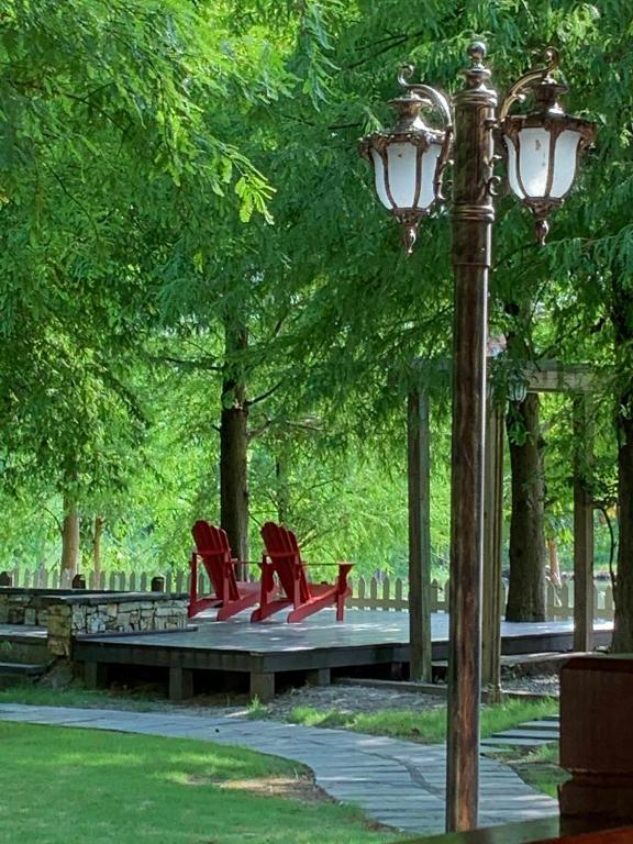 a park with red chairs and a light pole at Rothenburg Lodge in Wujie