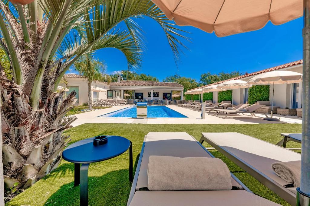 a villa with a pool and a palm tree at Hôtel Villa Sophia - ADULTS ONLY JULY AND AUGUST in Mougins